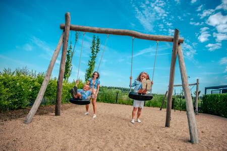 Children on the swing in a playground at holiday park EuroParcs Bad Hulckesteijn