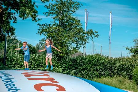 Children jump on the air trampoline in a playground at the EuroParcs Bad Hulckesteijn holiday park