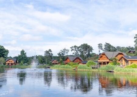 Wooden chalets on the recreational lake at the EuroParcs Brunssummerheide holiday park