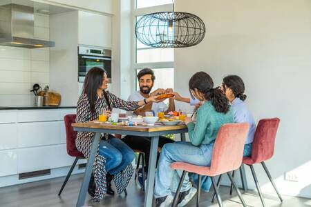 Family eating in the kitchen of a holiday home at the EuroParcs Buitenhuizen holiday park