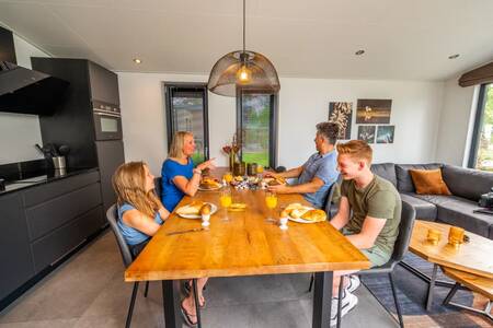 People at the kitchen table in a holiday home at the EuroParcs De Hooge Veluwe holiday park