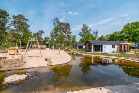 Playground next to water and holiday homes at the EuroParcs De Hooge Veluwe holiday park