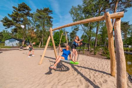 Children play on the swing in a playground at the EuroParcs De Hooge Veluwe holiday park