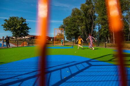 People playing football on the panna field at holiday park EuroParcs De IJssel Eilanden