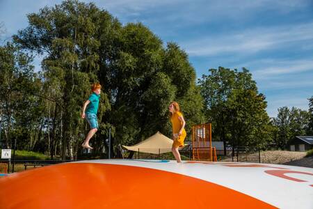 Children on an air trampoline in the playground at holiday park EuroParcs De IJssel Eilanden