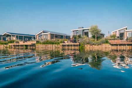 Chalets with jetties on the water at holiday park EuroParcs De Kraaijenbergse Plassen