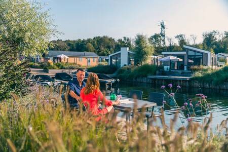 A couple on a jetty at a holiday home at the EuroParcs De Kraaijenbergse Plassen holiday park