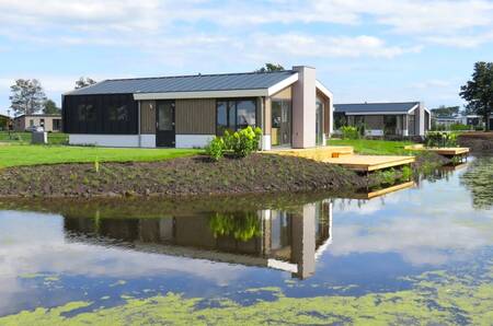 Detached holiday home with a decking on the water at the EuroParcs De Rijp holiday park