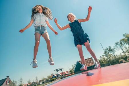 Children jump on the air trampoline at holiday park EuroParcs De Rijp