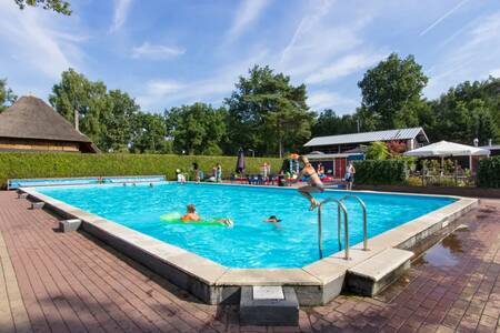 People swimming in the outdoor pool of holiday park EuroParcs De Wije Werelt