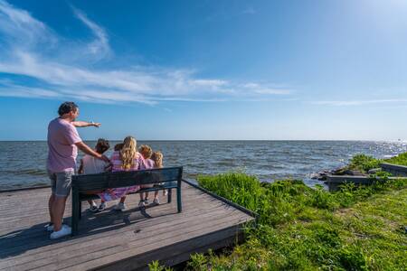 Family looks out over the IJsselmeer at the EuroParcs Enkhuizer Strand holiday park