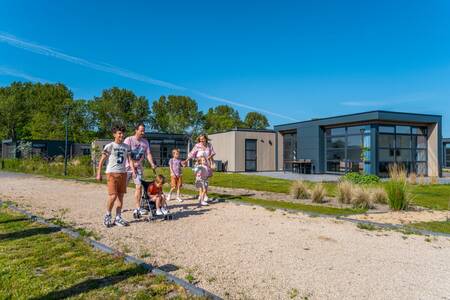 Family walks in front of holiday homes at the EuroParcs Enkhuizer Strand holiday park