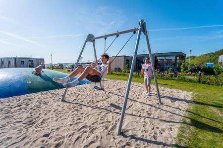 Child on the swing in the playground at the EuroParcs Enkhuizer Strand holiday park
