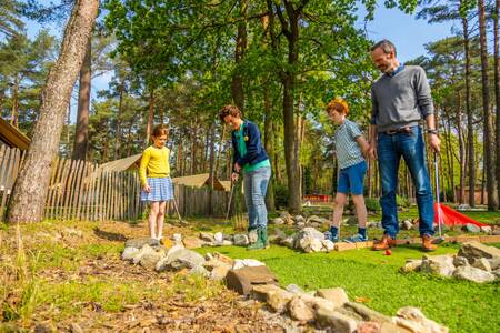 Family playing golf on the miniature golf course of the EuroParcs Hoge Kempen holiday park