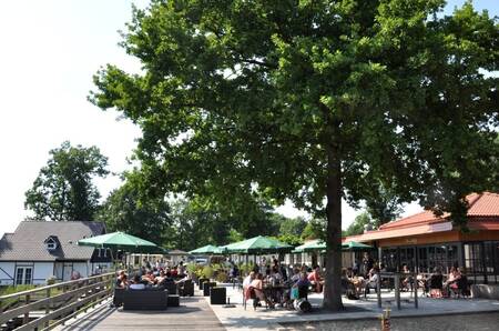 People on the terrace of the restaurant at holiday park EuroParcs Limburg