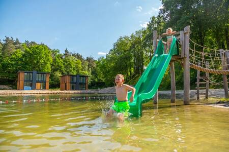 Children play on playground equipment in the water at the EuroParcs Maasduinen holiday park