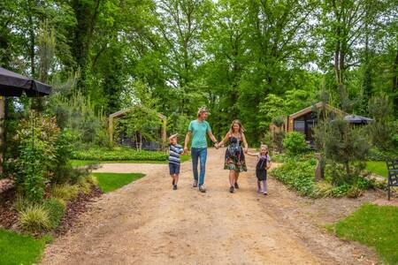 The family walks between the holiday homes at the EuroParcs Maasduinen holiday park