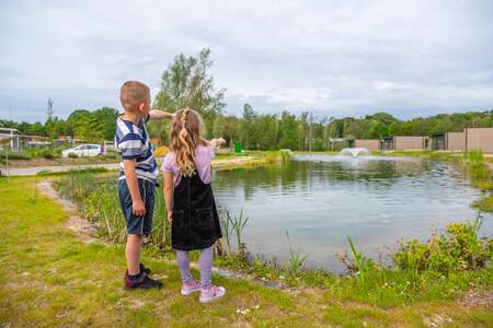 2 Children next to a pond with a fountain at the EuroParcs Maasduinen holiday park