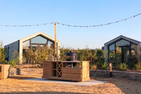 A barbeque place between chalets at holiday park EuroParcs Marina Strandbad