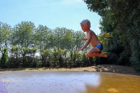 Child jumps on the air trampoline at holiday park EuroParcs Marina Strandbad