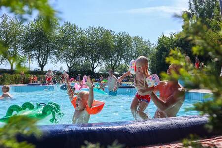 People swimming in the outdoor pool of holiday park EuroParcs Marina Strandbad