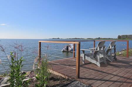 Chairs on a jetty with a view over the Markermeer at the EuroParcs Markermeer holiday park
