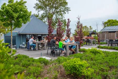 People eating on the terrace of the snack bar at the EuroParcs Markermeer holiday park