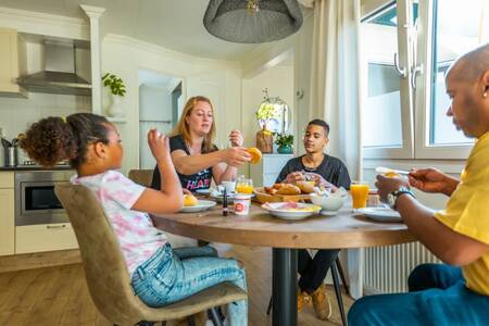 Family at the table in the kitchen of a holiday home at the EuroParcs Molengroet holiday park