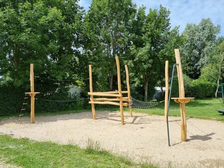 Wooden play equipment in a playground at the EuroParcs Molengroet holiday park