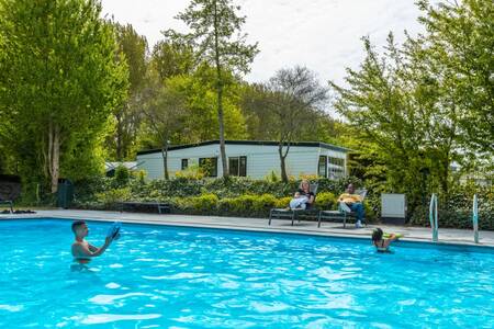 Children swim in the outdoor pool of holiday park EuroParcs Molengroet