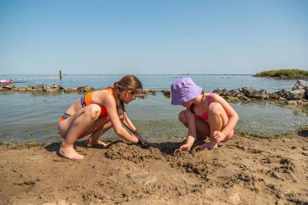 Children play in the sand on the beach at the EuroParcs Poort van Amsterdam holiday park
