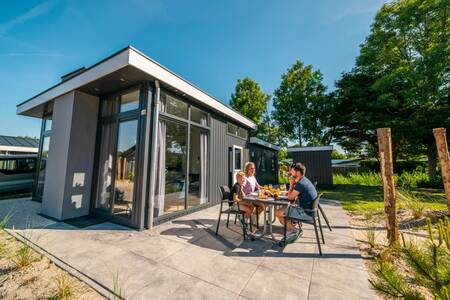 Family eating in the garden of a holiday home at the EuroParcs Poort van Zeeland holiday park