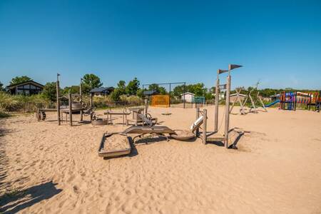 Play equipment in a large playground in the sand at the EuroParcs Poort van Zeeland holiday park