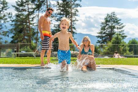 Family in the outdoor pool of the EuroParcs Pressegger See holiday park