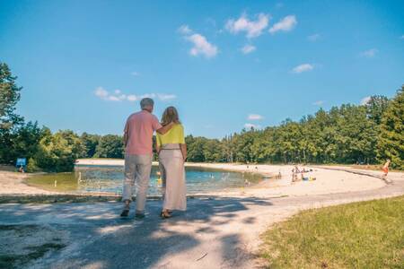 A couple walks on a beach near the EuroParcs Reestervallei holiday park
