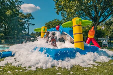 Children play in the foam on an air cushion at the EuroParcs Reestervallei holiday park