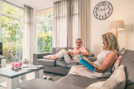 Couple on the couch in a holiday home at the EuroParcs Reestervallei holiday park