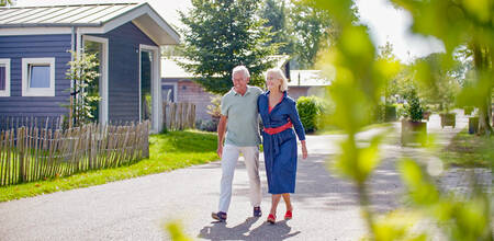 A couple walks between holiday homes at the EuroParcs Reestervallei holiday park