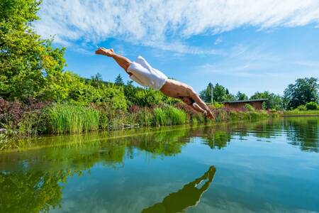 Man takes a dip in the swimming pond of holiday park EuroParcs Rosental