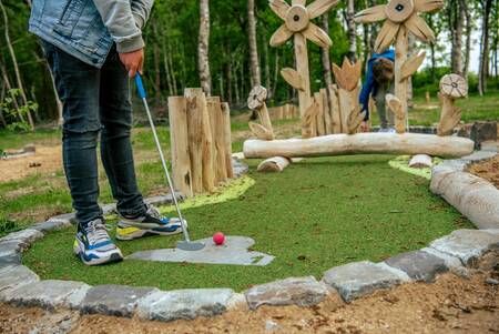 People playing golf on the miniature golf course of holiday park EuroParcs Ruinen
