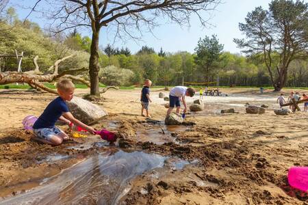 Children play with sand and water in the nature playground at the EuroParcs Ruinen holiday park