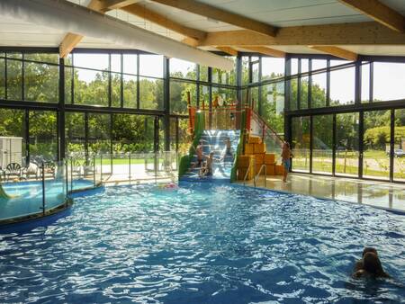 Children slide down the wide slide in the swimming pool of the EuroParcs Ruinen holiday park