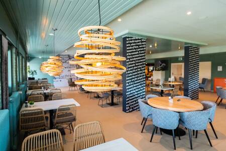 Tables with chairs in the atmospheric restaurant at the EuroParcs Schoneveld holiday park