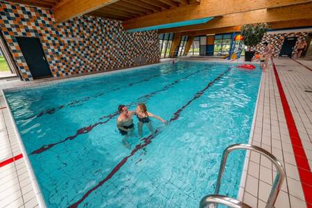 Couple swimming in the indoor pool of holiday park EuroParcs Schoneveld