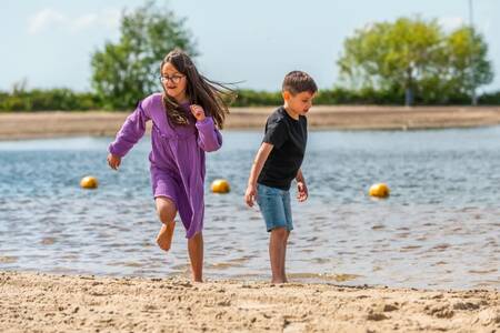 Children play on the beach of the Veluwemeer at holiday park EuroParcs Veluwemeer