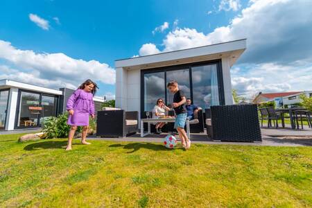 The family relaxes in the garden of a holiday home at the EuroParcs Veluwemeer holiday park