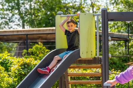 Boy on the slide in a playground at the EuroParcs Veluwemeer holiday park