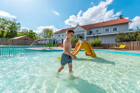 Children in the paddling pool of the outdoor pool at the EuroParcs Veluwemeer holiday park