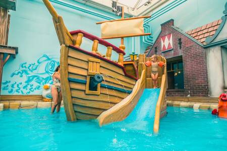 Child on a small slide in the swimming pool of the EuroParcs Zuiderzee holiday park