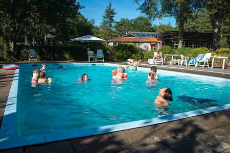 People swim in the outdoor pool of holiday park EuroParcs de Wiltzangh